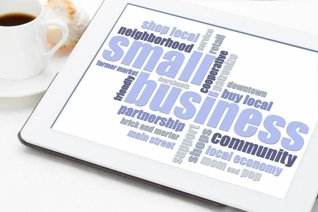 small business word cloud on a digital tablet with a cup of coffee