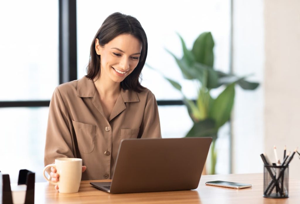Woman entrepreneur reading financial statements calmly over coffee