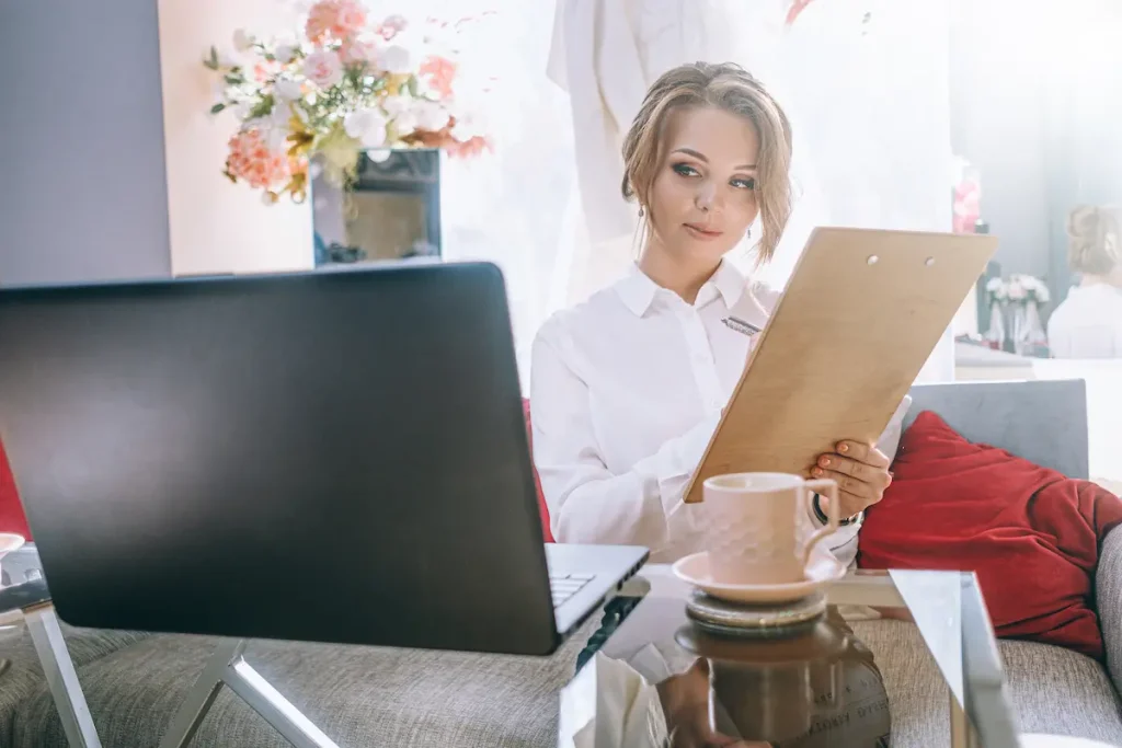 Woman enjoying a coffee while reviewing finances on her laptop, illustrating monthly money dates for calm, stress-free bookkeeping